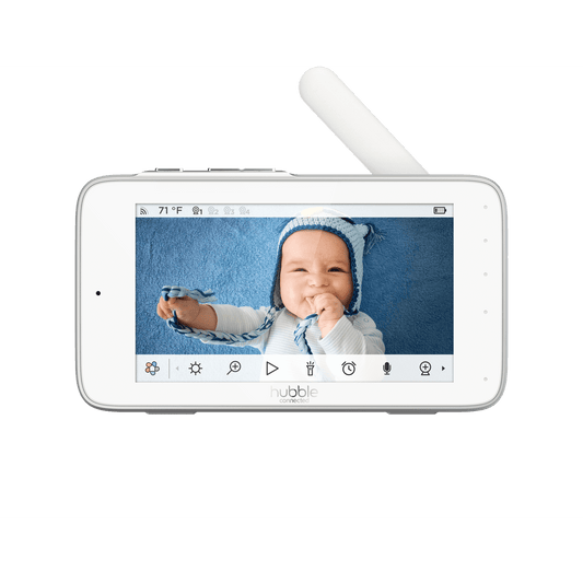 A white baby monitor displaying a baby on screen, with control icons below the display