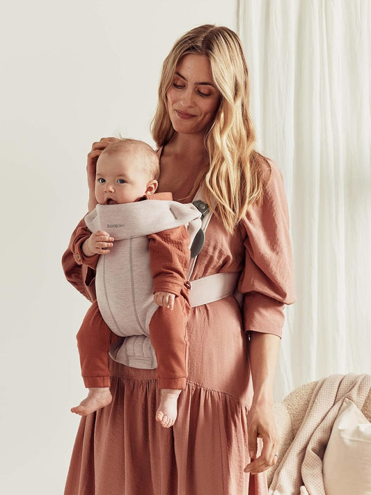 Image displaying a woman and a baby in a baby carrier and text about it's details