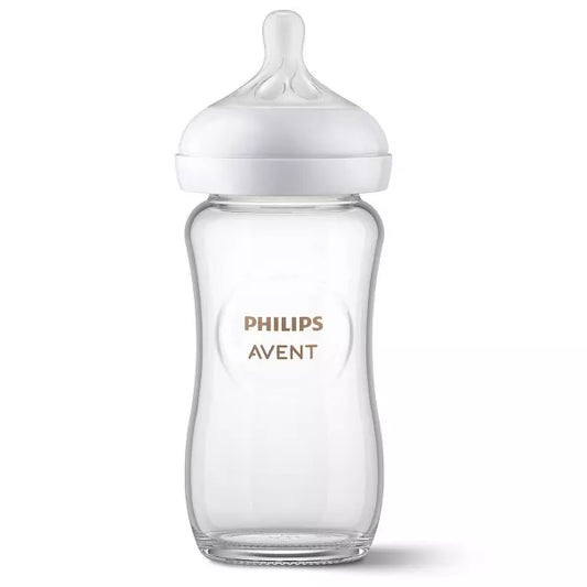 Clear baby bottle with white cap on a white background.