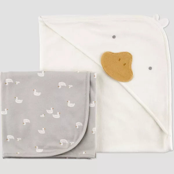 Gray blanket with duck pattern and white towel on a light gray background
