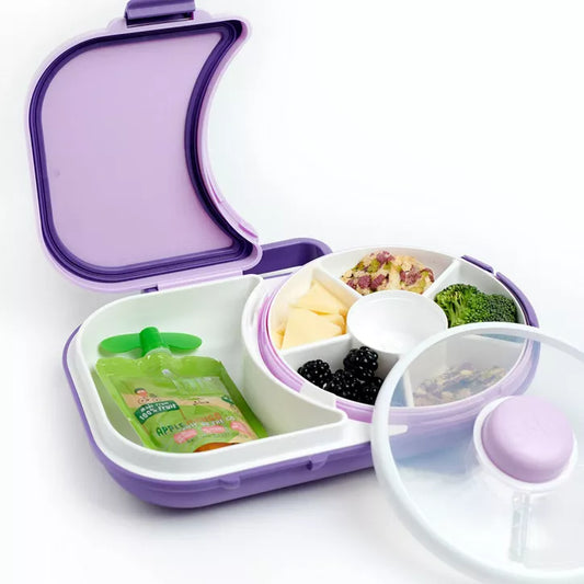 Purple and white bento lunch box with compartments containing food on a white background