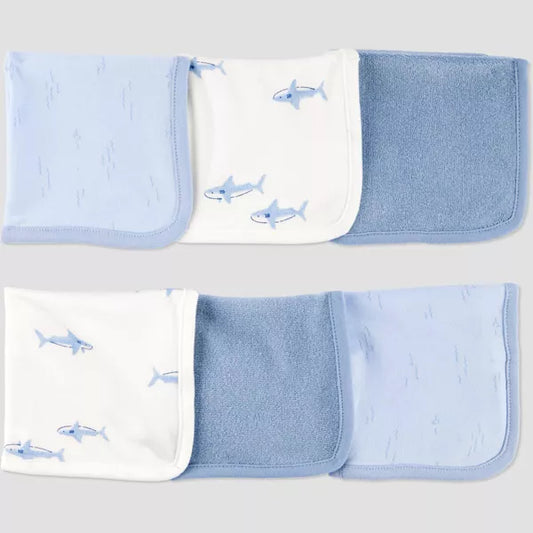 Set of blue baby blankets with shark patterns on a light gray background