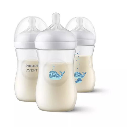 Three baby bottles with milk inside on a white background