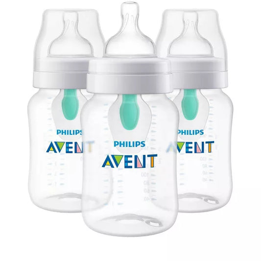 Three baby bottles with white caps on a white background