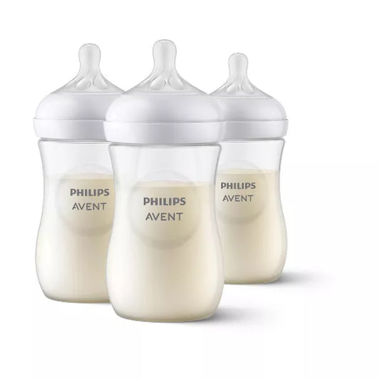 Three baby bottles with white caps on a white background