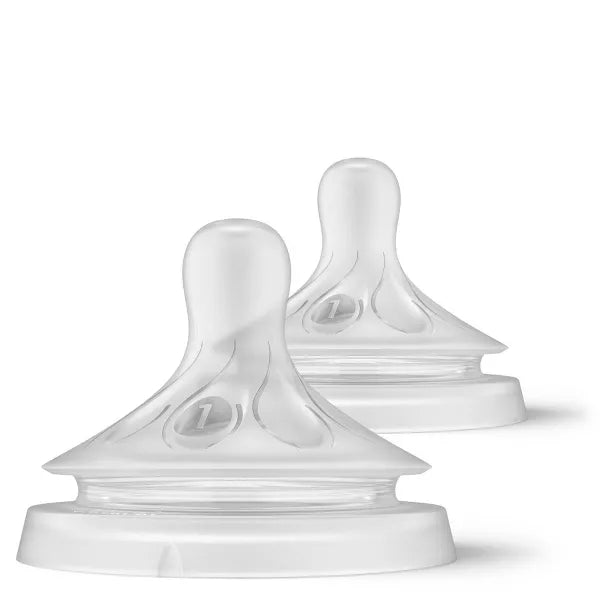 Two white baby bottle nipples on a white background