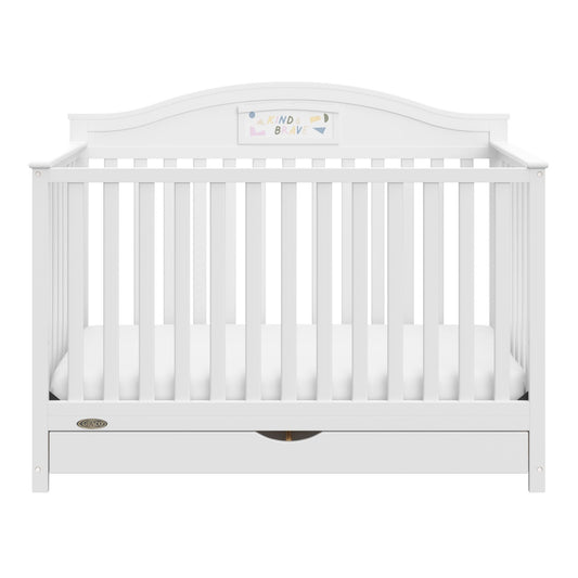 A white baby crib with vertical slats, a curved headboard, and a storage drawer underneath