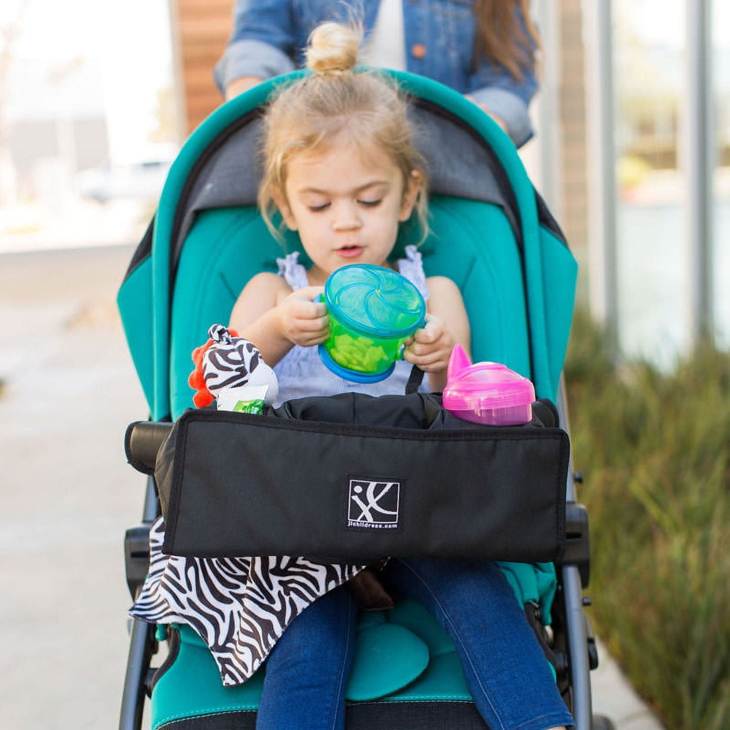 Image displying a baby in a baby stroller with a baby stroller accessory