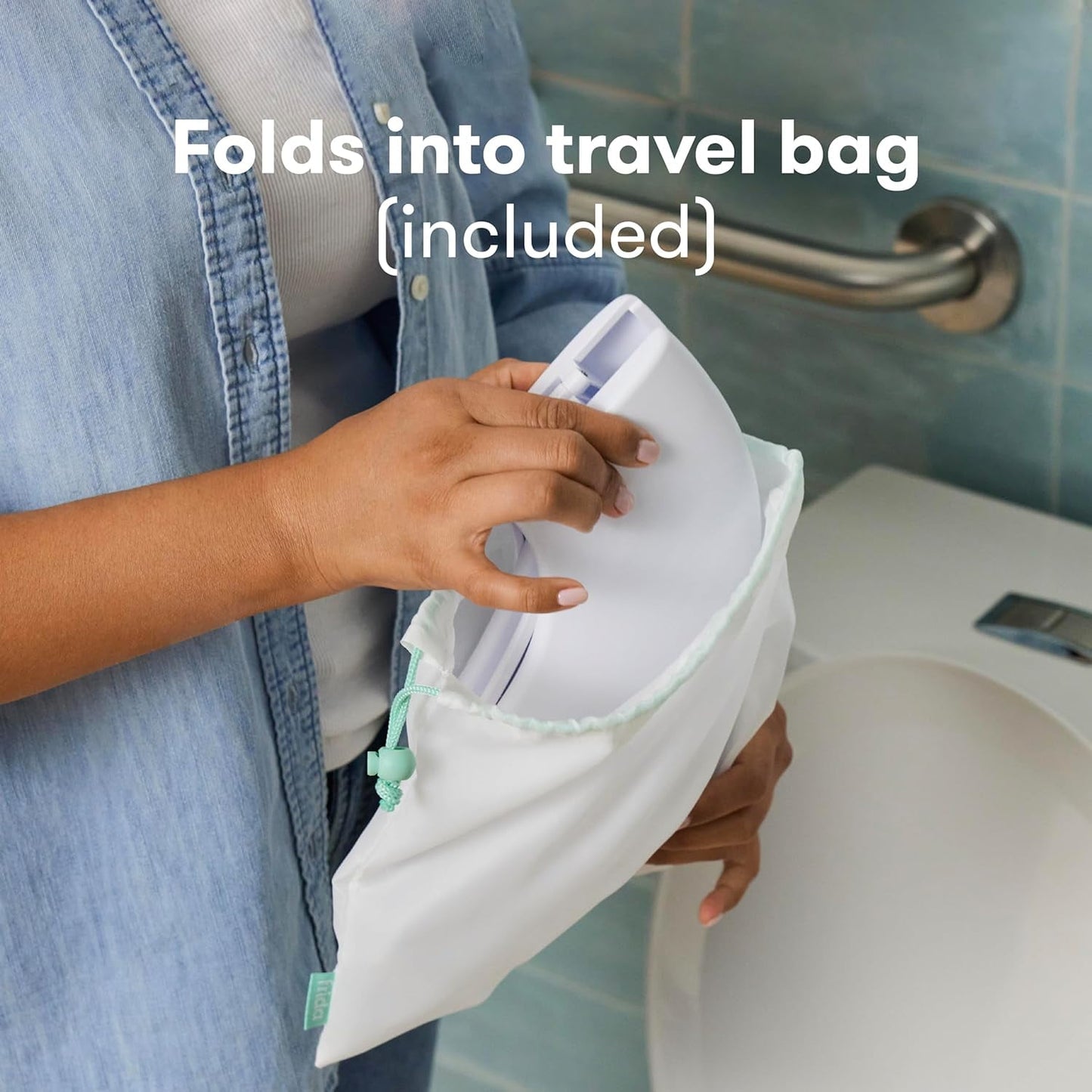 A person places a white foldable potty seat into a light-colored travel bag