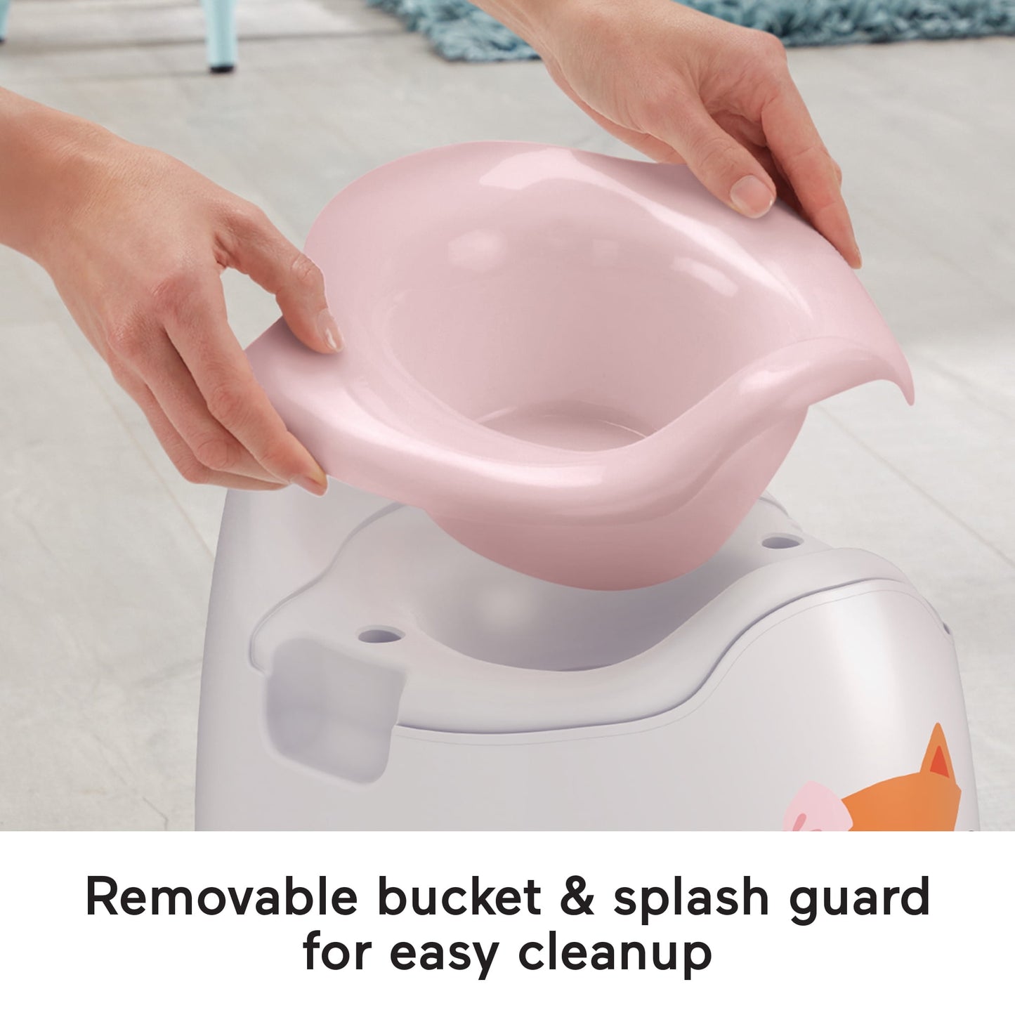 Hands removing a pink potty bucket from a white potty chair, with white label at the bottom