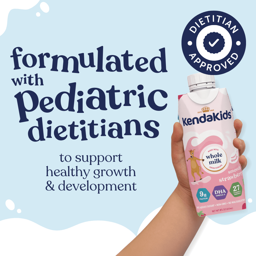 Hand holding a strawberry-flavored nutritional drink carton for kids, with text and a dietitian seal