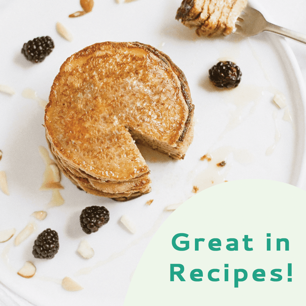 A stack of pancakes with a slice removed, with blackberries and almonds, with white background