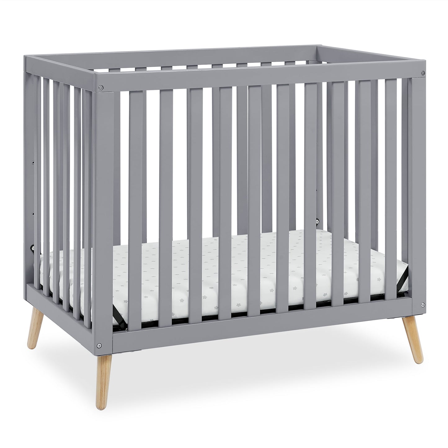 A grey baby crib with a mattress, featuring wooden legs and slatted sides