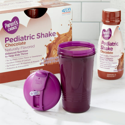 Chocolate pediatric shake bottles, box, and a purple cup filled with shake with lid on a white surface