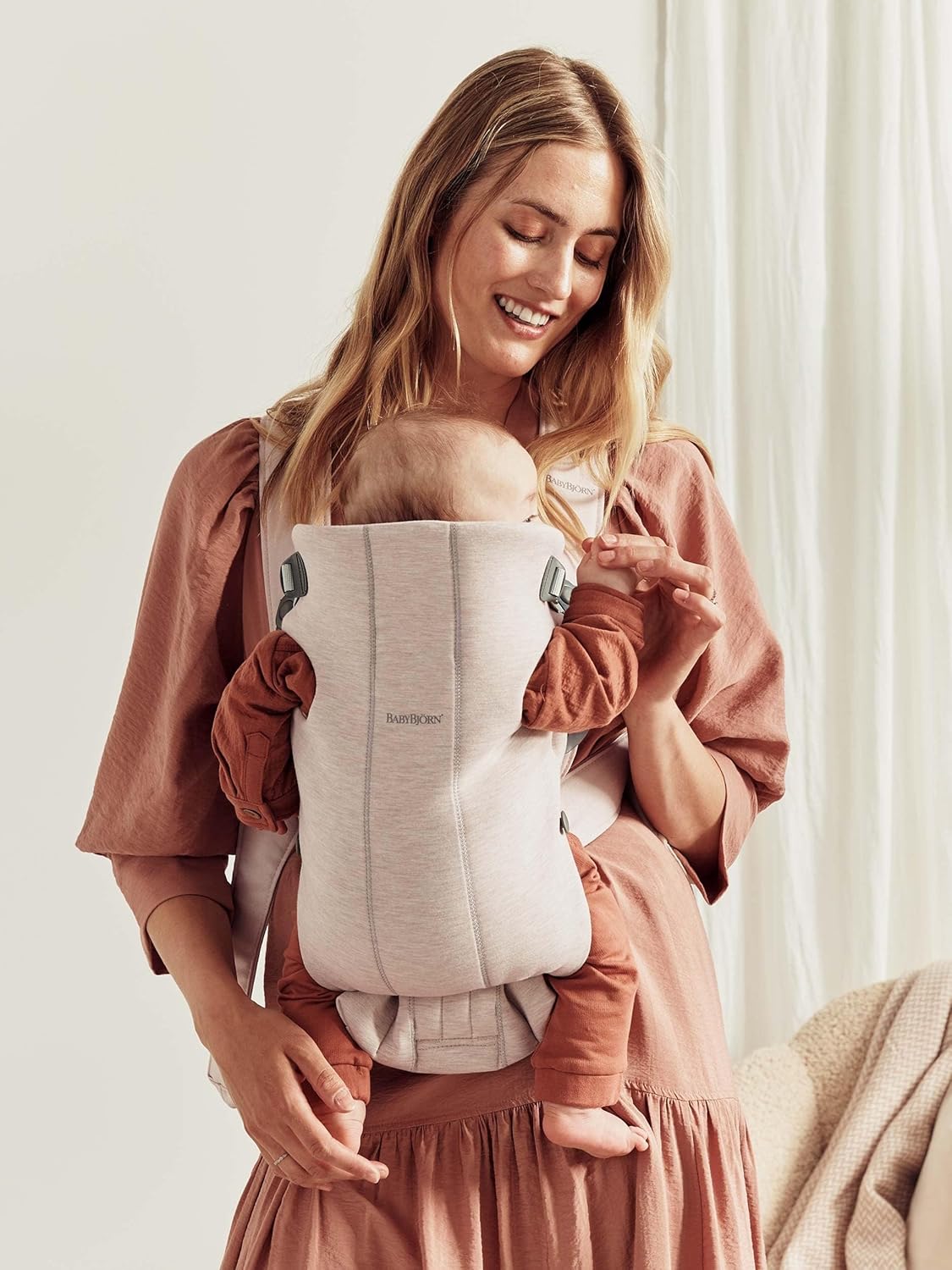 Image displaying a woman and a baby in a baby carrier and text about it's details