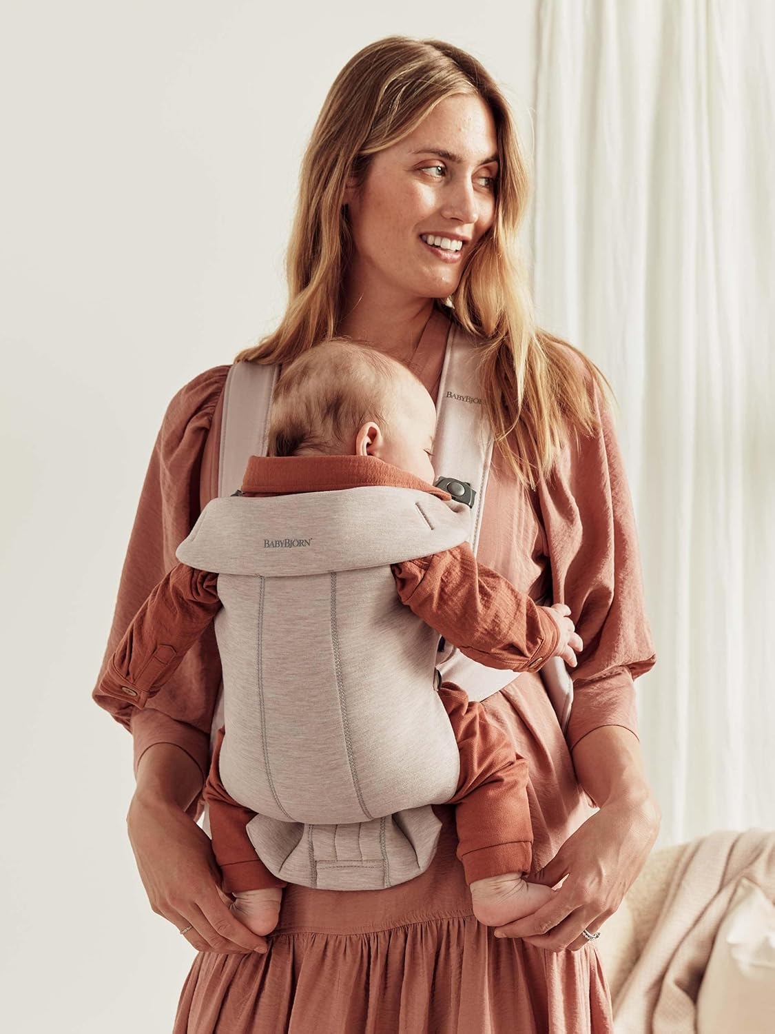 Image displaying a woman and a baby in a baby carrier and text about it's details