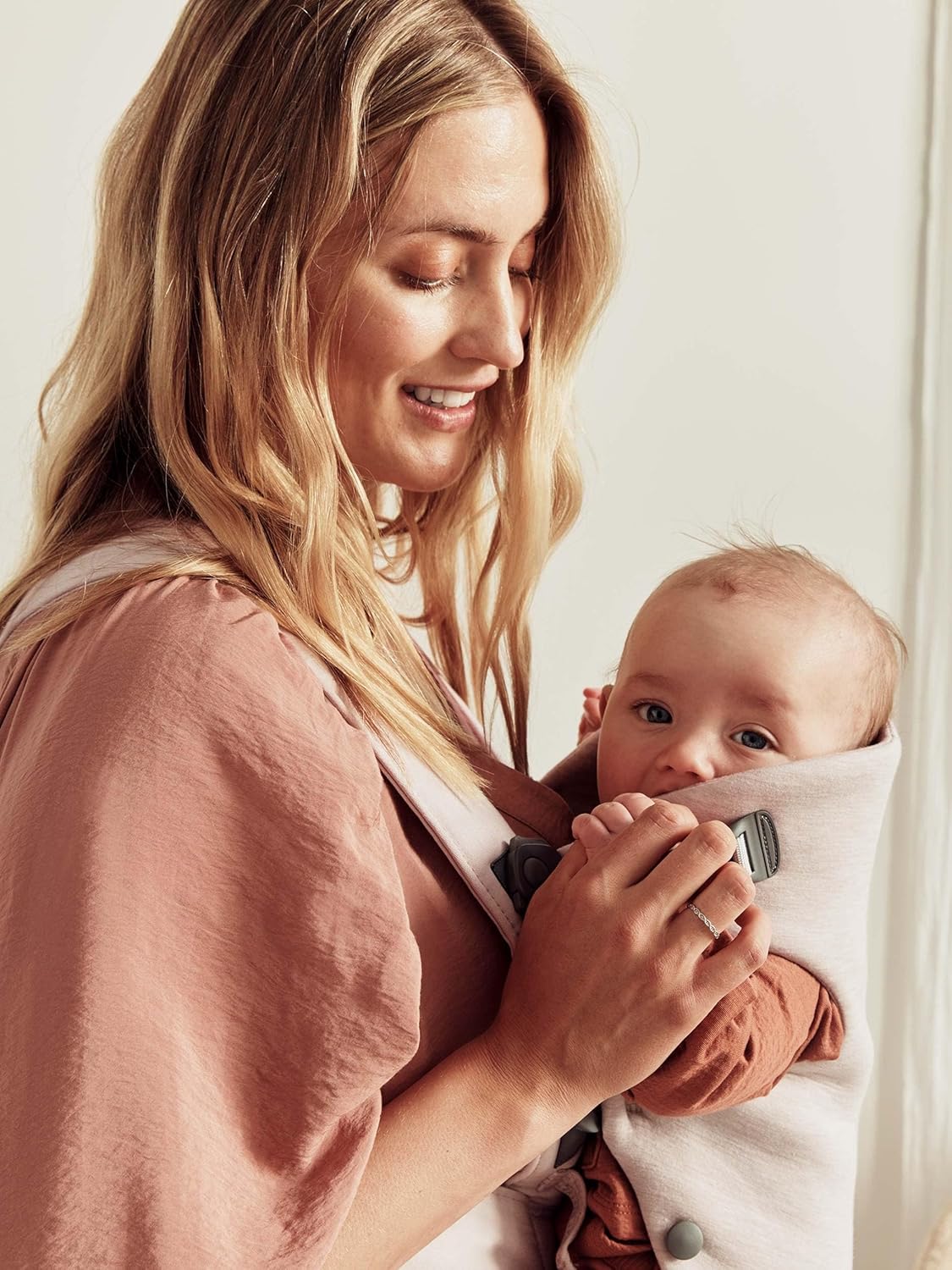 Image displaying a woman and a baby in a baby carrier and text about it's details