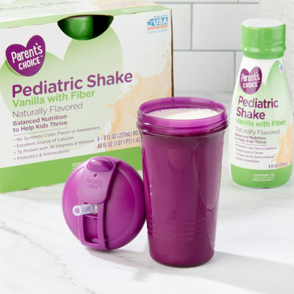Kids pediatric shake bottles, box, and a purple cup filled with shake with lid on a white surface, Vanilla with fiber