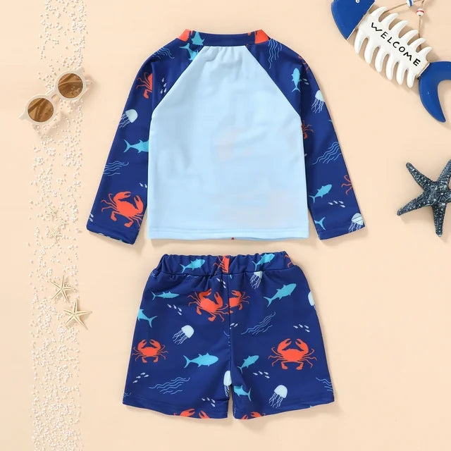 Children's swim set with blue and light blue top and shorts featuring sea creature patterns on a beige background.