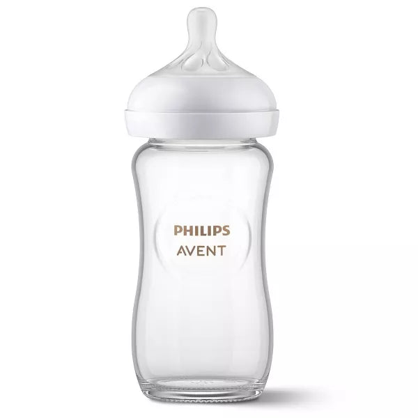Clear baby bottle with white cap on a white background.