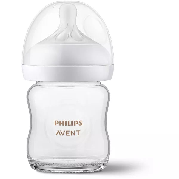 Clear baby bottle with white cap on a white background.