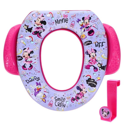 A purple and pink child's toilet training seat featuring cartoon characters, with a matching pink hook