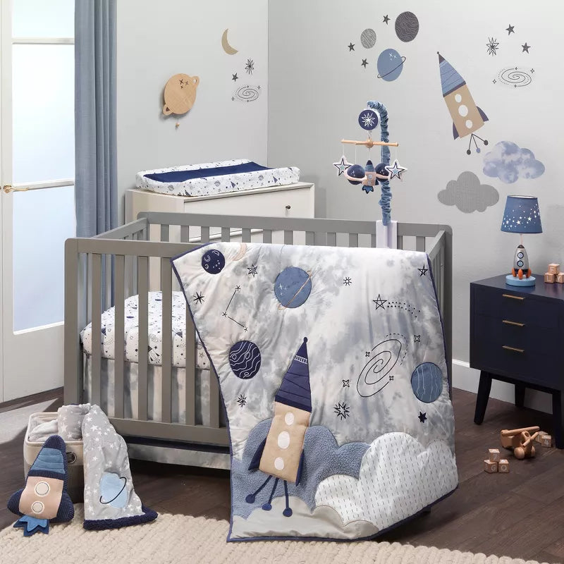A baby nursery with a crib, space-themed bedding, mobile, wall decals, and changing pad