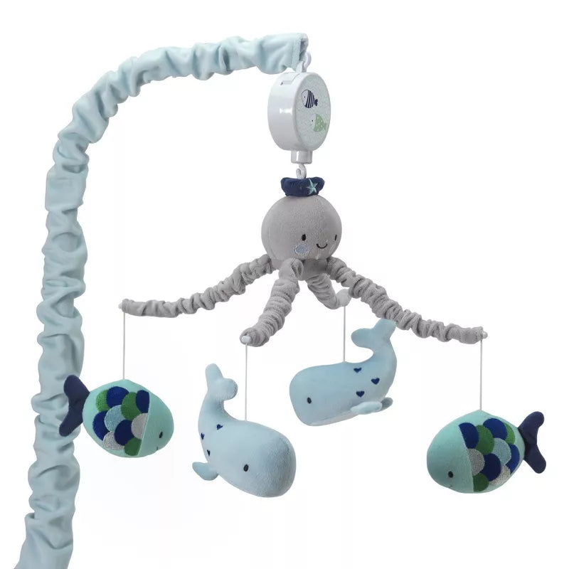 A baby crib mobile featuring an octopus, whales, and fish hanging from an arm