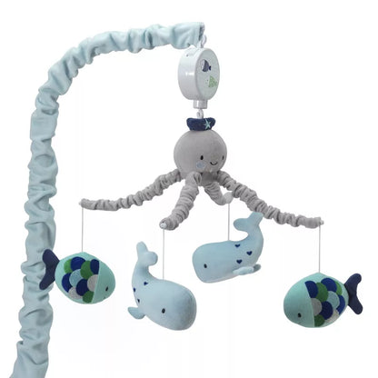 A baby crib mobile featuring an octopus, whales, and fish hanging from an arm