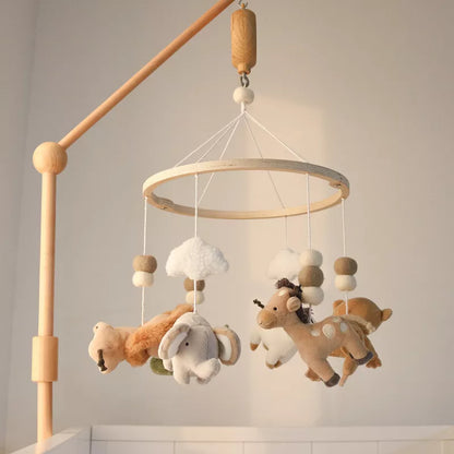 A wooden baby crib mobile hangs with plush safari animals and clouds, serving as nursery décor