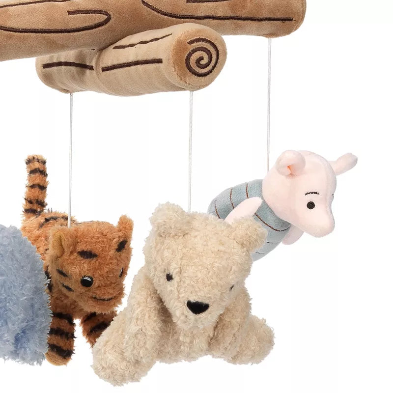 Stuffed animals of a bear, a pig, and a tiger hanging from a wooden-look mobile
