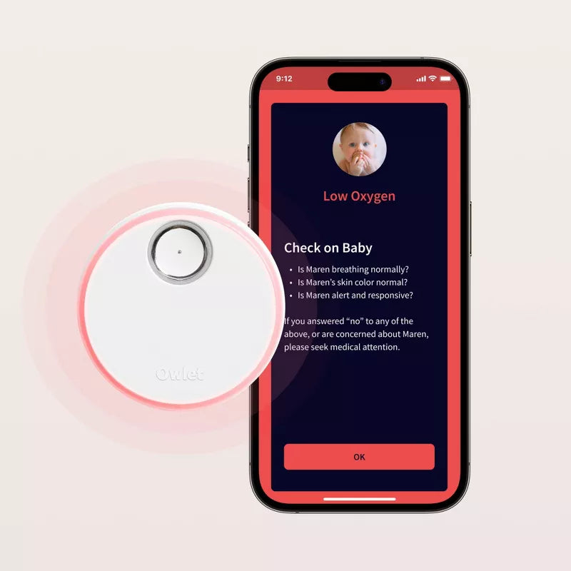 Baby health sensor next to smartphone showing live readings on screen