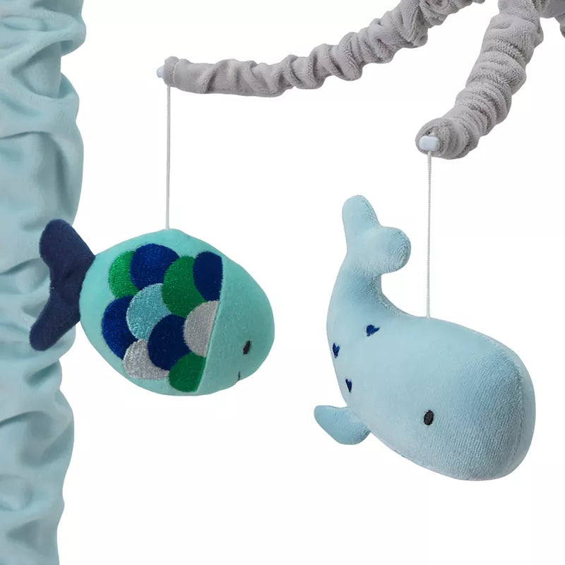 Baby crib mobile with hanging plush fish and whale toys, part of a nursery decor product