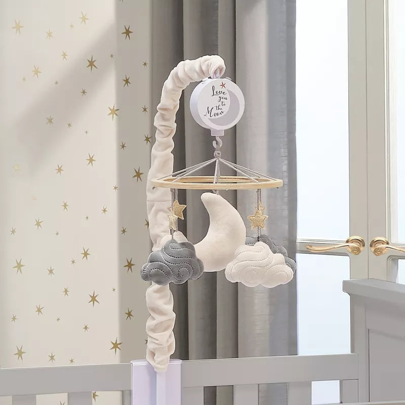A baby crib mobile featuring a moon, stars, and clouds, attached to a crib
