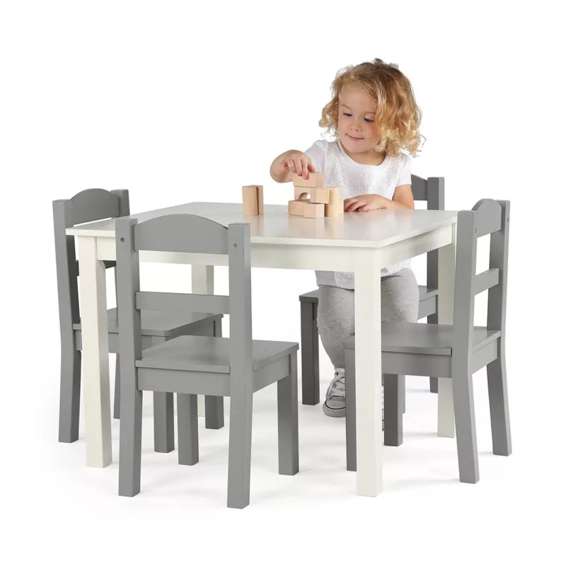 A child playing with blocks at a small white and grey table with four matching chairs