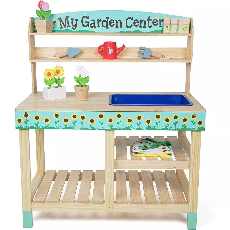 A wooden toy gardening center playset with shelves, a sink, tools, and potted flowers