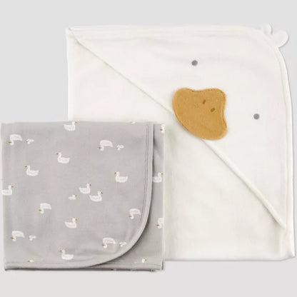 Gray blanket with duck pattern and white towel on a light gray background
