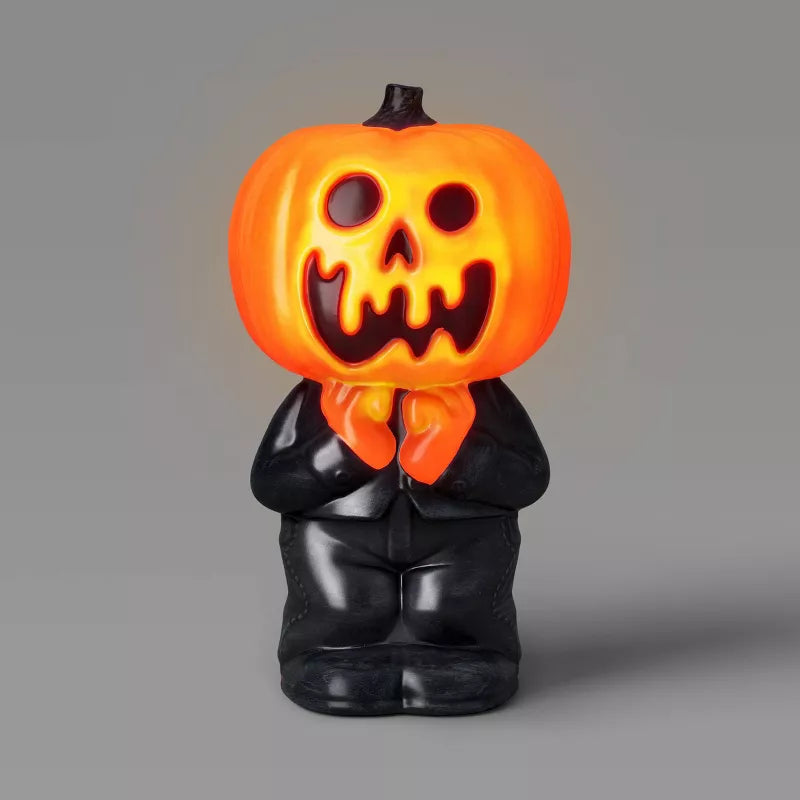 Halloween-themed figurine with a glowing orange pumpkin head on a gray background