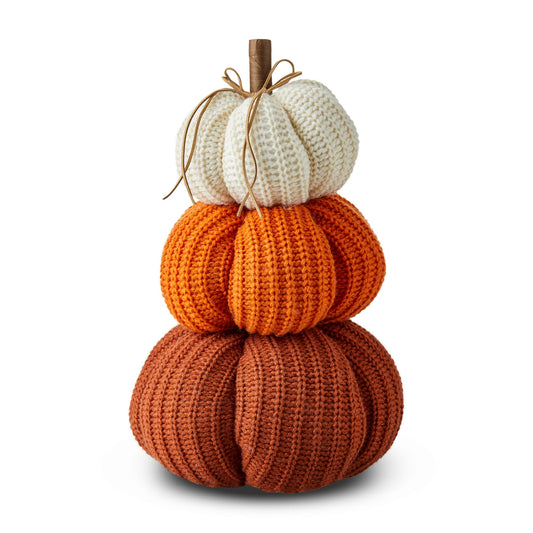 Halloween Themed Stack of knitted pumpkins in orange, white, and brown on a white background