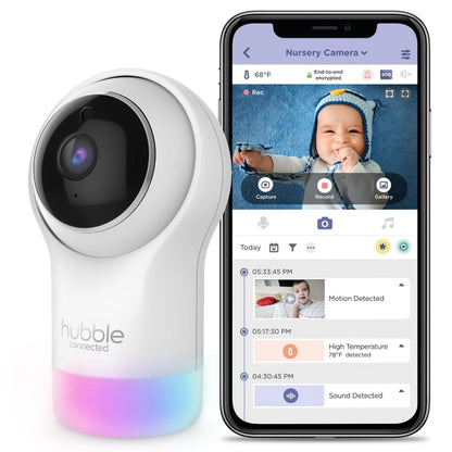 A baby monitor camera and a smartphone displaying the monitor's app interface with a baby's image