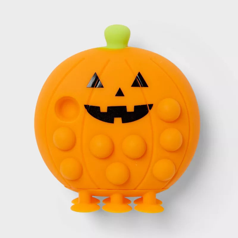 Pumpkin-shaped pop-it toy with a jack-o'-lantern face on a white background