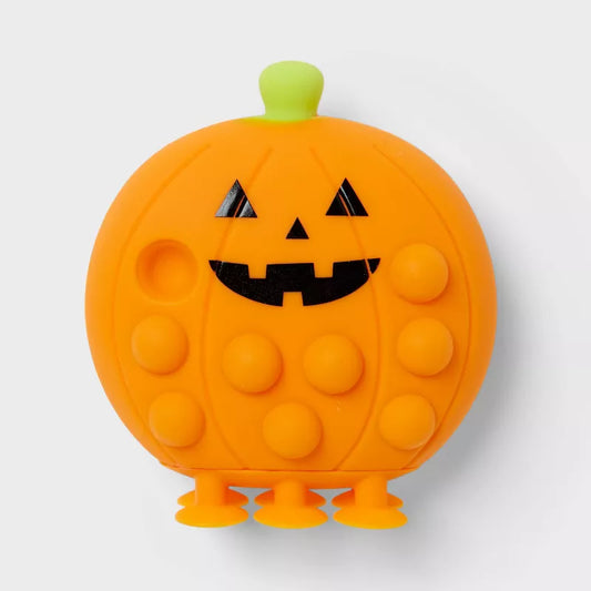Pumpkin-shaped pop-it toy with a jack-o'-lantern face on a white background