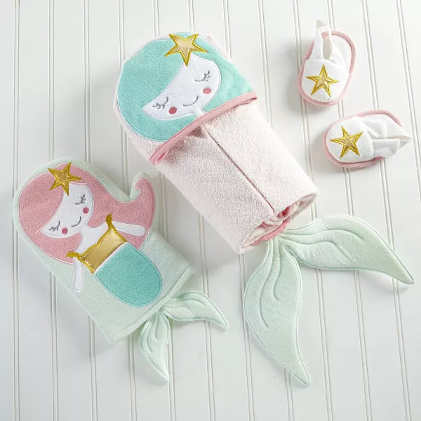 Set of baby accessories including a towel, mittens, and booties with mermaid design on a white background.