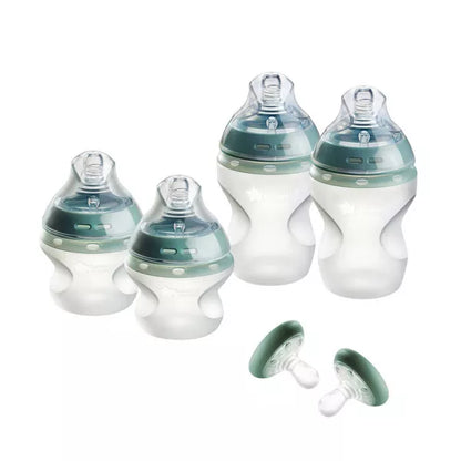 Set of baby bottles and pacifiers on a white background