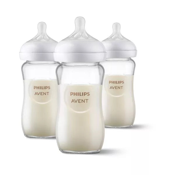 Three baby bottles filled with milk on a white background