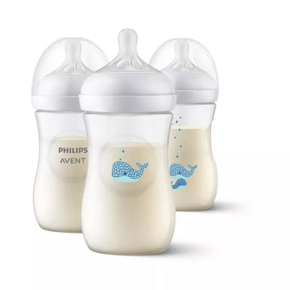 Three baby bottles with milk inside on a white background