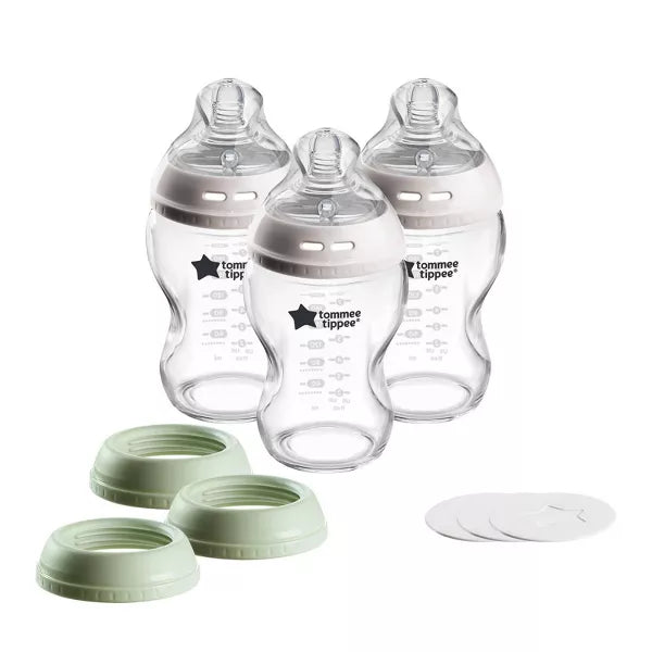 Three baby bottles with green and white caps on a white background