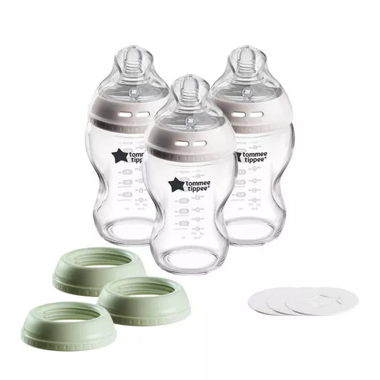 Three baby bottles with green and white caps on a white background