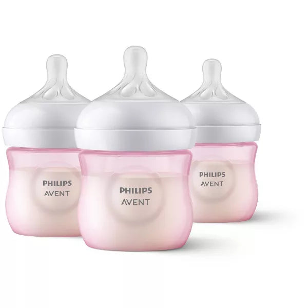 Three baby bottles with pink bases on a white background
