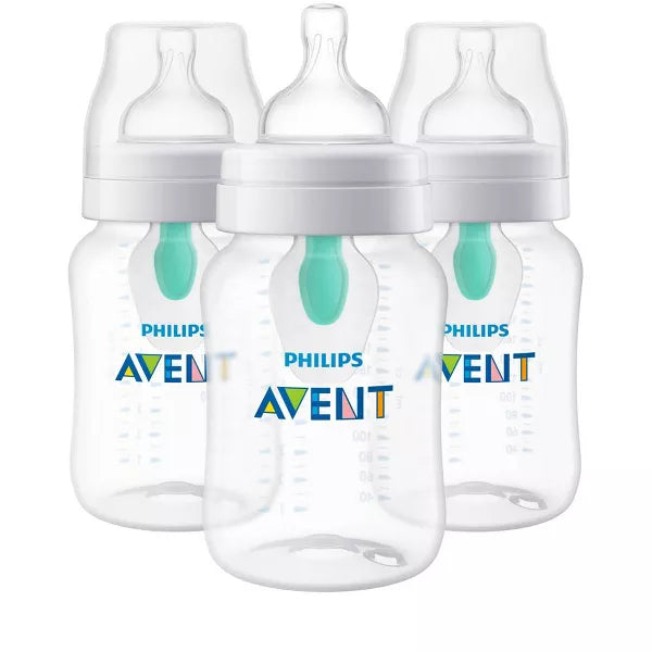 Three baby bottles with white caps on a white background